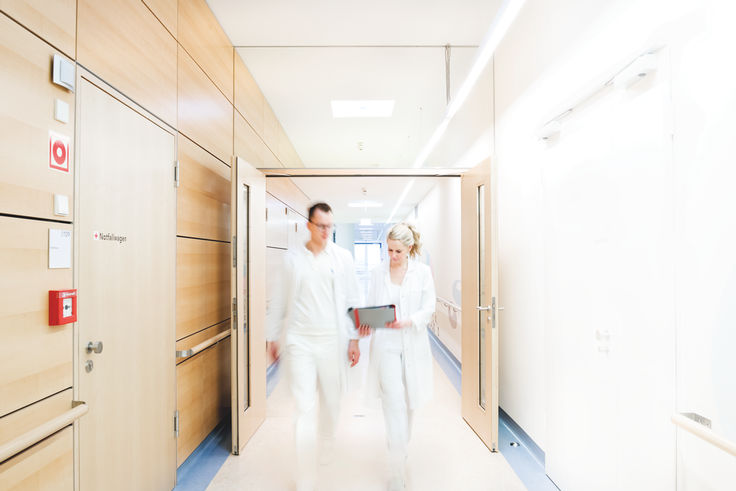 Hospital staff passing through a double-leaf door