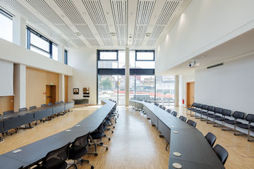 In Konferenz- und Sitzungssälen, Bürogebäuden oder Schulen geht es oft hoch her und die Luft wird entsprechend dünn. Natürliche Lüftung über smart gesteuerte Fenster können hier energieeffizient unterstützen.
