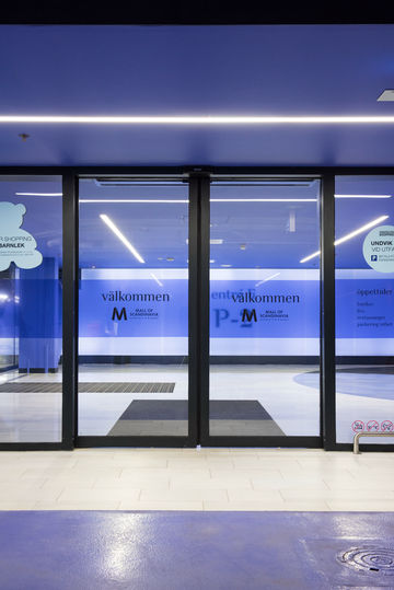 Sistem de ușă glisantă din sticlă, la intrarea la nivelul parcării din Mall of Scandinavia.